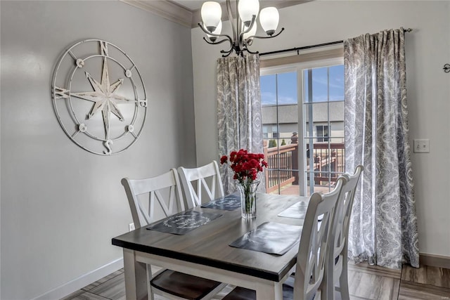 dining room featuring baseboards, crown molding, an inviting chandelier, and wood finished floors