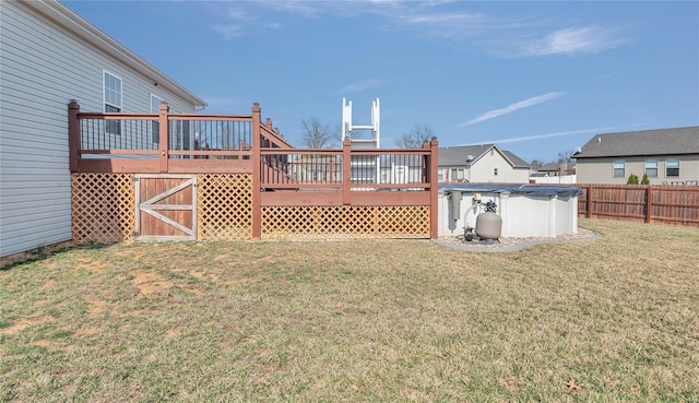 view of yard with a fenced in pool, fence, and a wooden deck