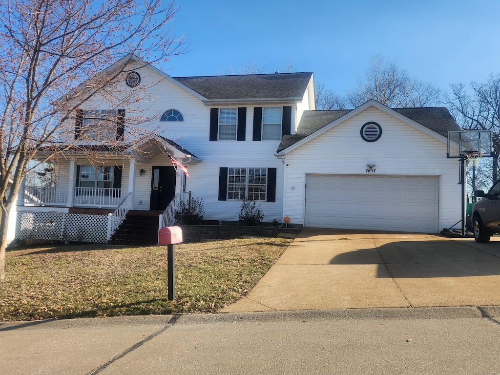 view of front of home featuring a porch, a front yard, a garage, and driveway