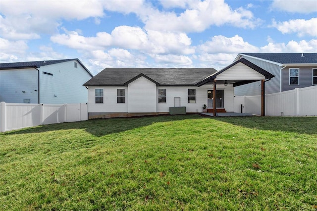 back of house with central AC unit, a yard, a patio area, and a fenced backyard