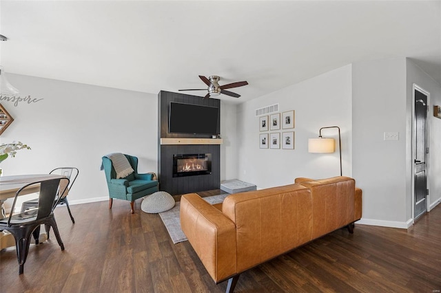 living area featuring visible vents, wood finished floors, a fireplace, baseboards, and ceiling fan