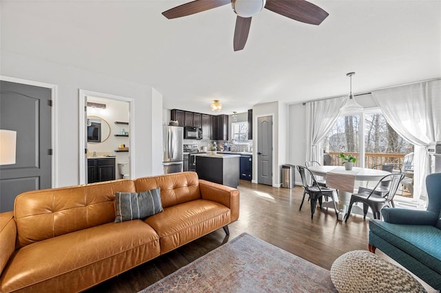 living area featuring a healthy amount of sunlight, wood finished floors, and a ceiling fan