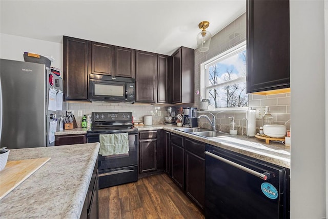 kitchen featuring black appliances, dark brown cabinets, light countertops, and a sink