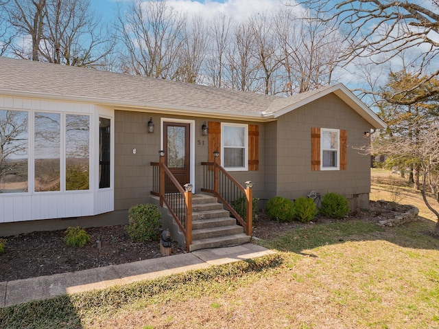 view of front facade featuring crawl space, a shingled roof, and a front lawn