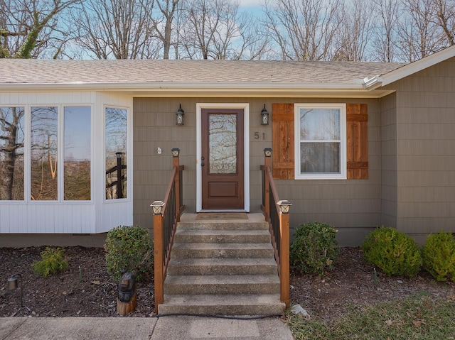 property entrance featuring roof with shingles