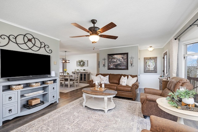 living area featuring a textured ceiling, ceiling fan, dark wood-style flooring, and ornamental molding