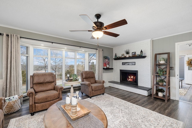 living room featuring a fireplace, crown molding, a ceiling fan, and wood finished floors