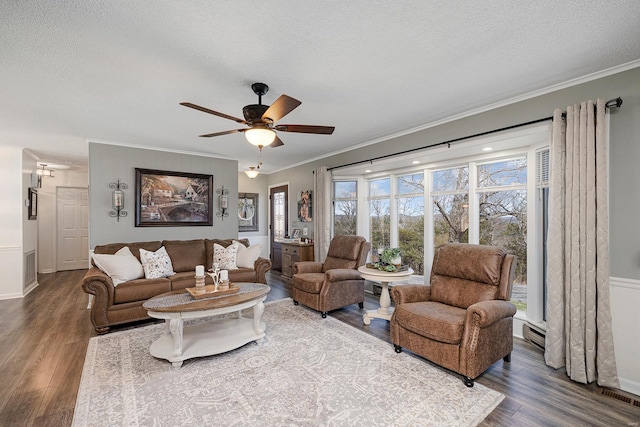 living room with ornamental molding, a textured ceiling, ceiling fan, and wood finished floors