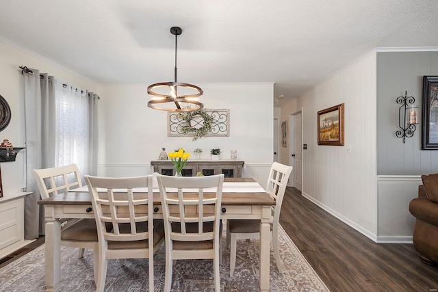 dining space featuring baseboards, dark wood finished floors, ornamental molding, a notable chandelier, and a textured ceiling