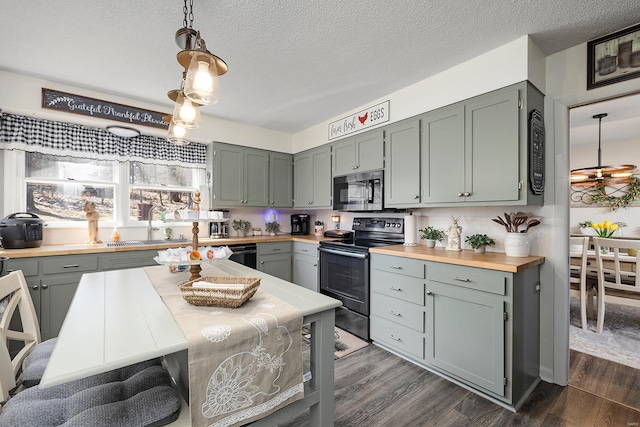 kitchen featuring a sink, pendant lighting, dark wood finished floors, and electric stove