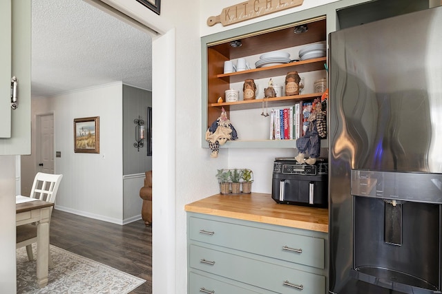 kitchen with ornamental molding, wood counters, a textured ceiling, dark wood-style floors, and stainless steel fridge with ice dispenser