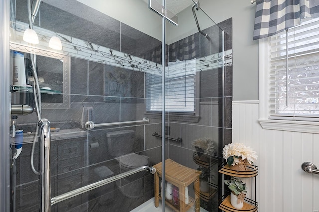 bathroom with a stall shower and wainscoting