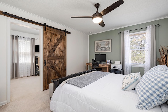 bedroom featuring a barn door, carpet, crown molding, and a textured ceiling