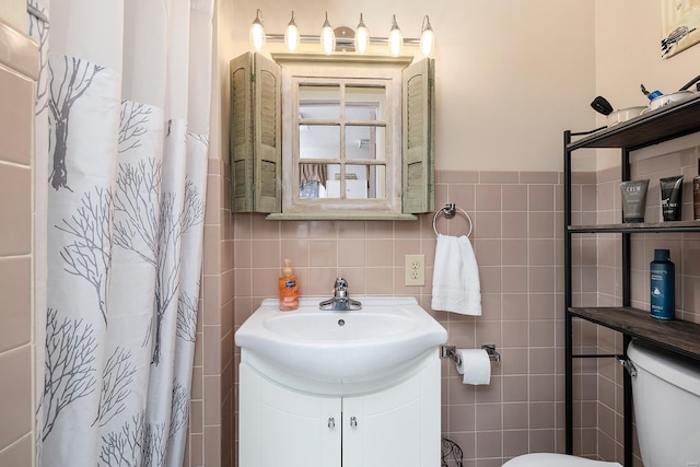 full bathroom with vanity, tile walls, curtained shower, and toilet