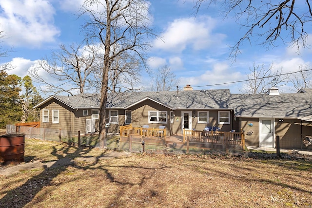 rear view of house with a gate, a fenced front yard, and a chimney