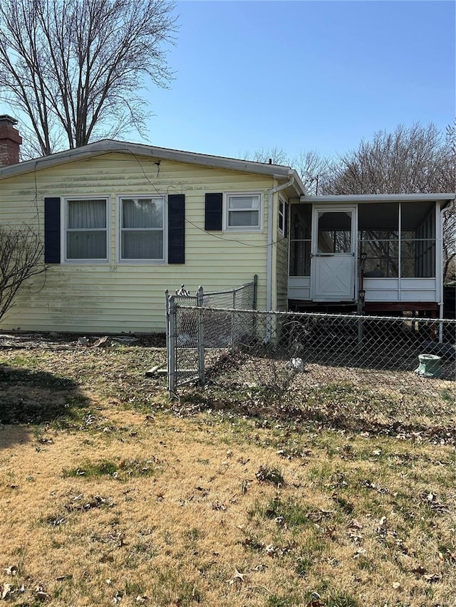 rear view of property with fence, a chimney, and a sunroom