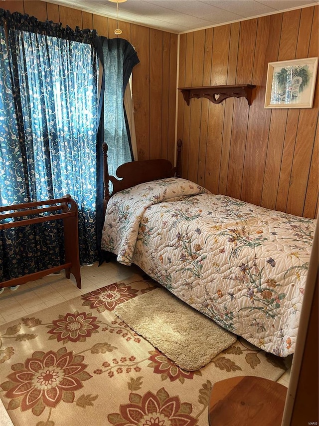 bedroom with light tile patterned flooring and wooden walls