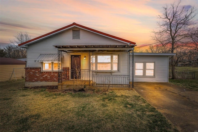 bungalow with brick siding, a porch, a yard, and fence