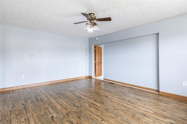 empty room featuring ceiling fan, a textured ceiling, baseboards, and wood finished floors