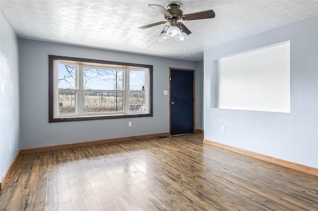 spare room with baseboards, a textured ceiling, wood finished floors, and a ceiling fan