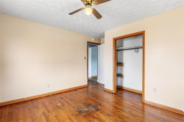 unfurnished bedroom featuring a textured ceiling, hardwood / wood-style floors, a closet, baseboards, and ceiling fan