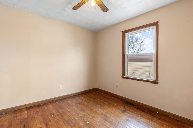 empty room featuring visible vents, baseboards, ceiling fan, and dark wood-style flooring