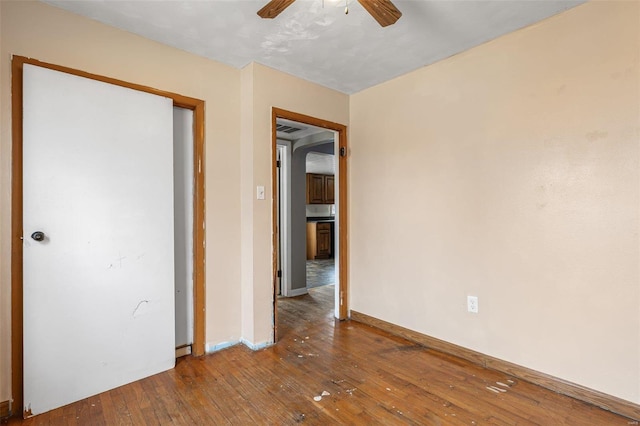 unfurnished bedroom featuring baseboards, ceiling fan, and hardwood / wood-style floors