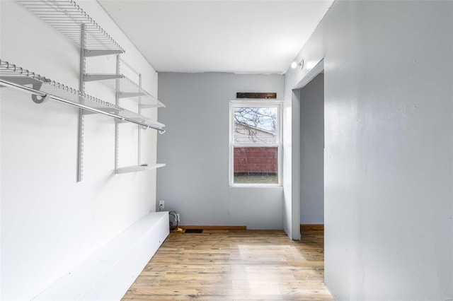 walk in closet with light wood-style floors