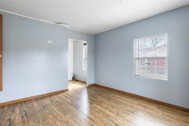 unfurnished room with baseboards and wood finished floors