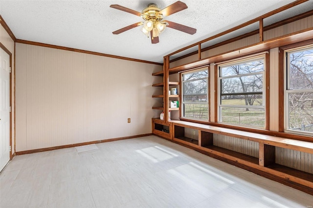 empty room featuring a textured ceiling, a healthy amount of sunlight, and ceiling fan