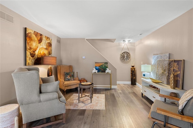 sitting room with hardwood / wood-style floors, baseboards, and visible vents