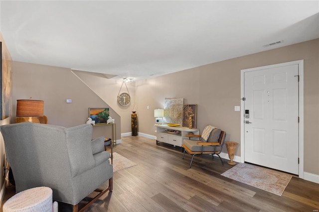 living room featuring wood finished floors, visible vents, and baseboards