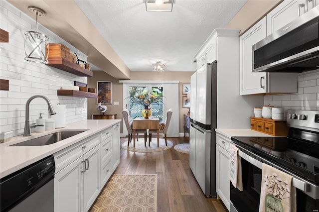 kitchen featuring white cabinets, appliances with stainless steel finishes, light countertops, and a sink