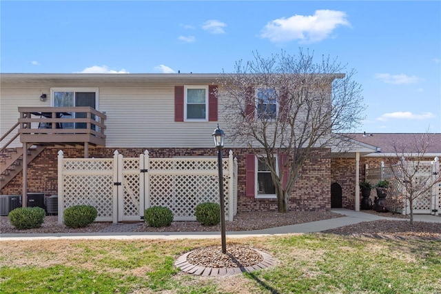 exterior space with fence, brick siding, and a lawn