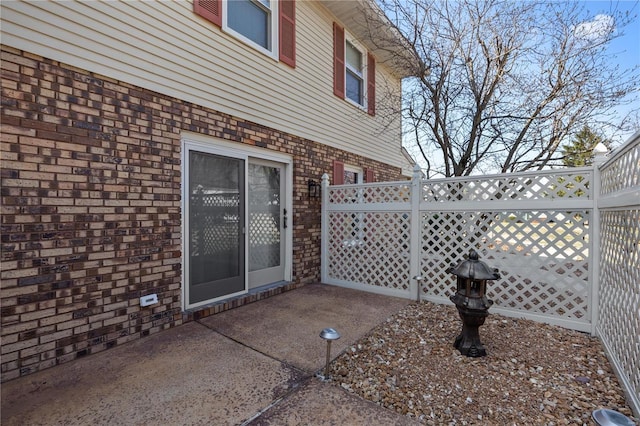 exterior space with brick siding, a patio, and fence