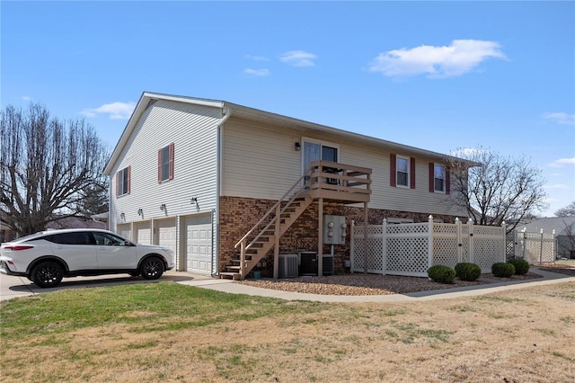 view of front facade with fence, stairway, a front yard, a garage, and driveway