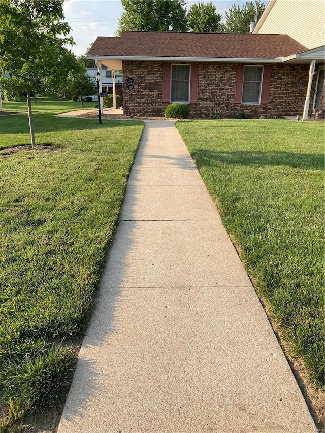 view of front facade featuring brick siding and a front lawn