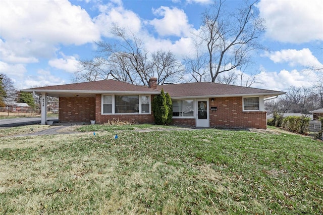 ranch-style house with brick siding, an attached carport, a chimney, and a front yard