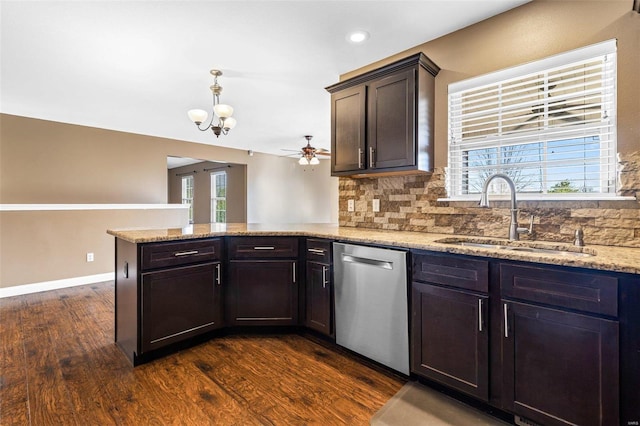 kitchen featuring dark wood-style flooring, ceiling fan with notable chandelier, a peninsula, stainless steel dishwasher, and a sink