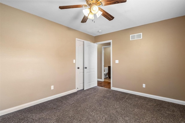 unfurnished room with baseboards, visible vents, dark colored carpet, and ceiling fan