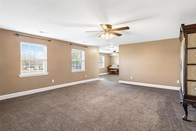 unfurnished living room with visible vents, carpet floors, baseboards, and a ceiling fan