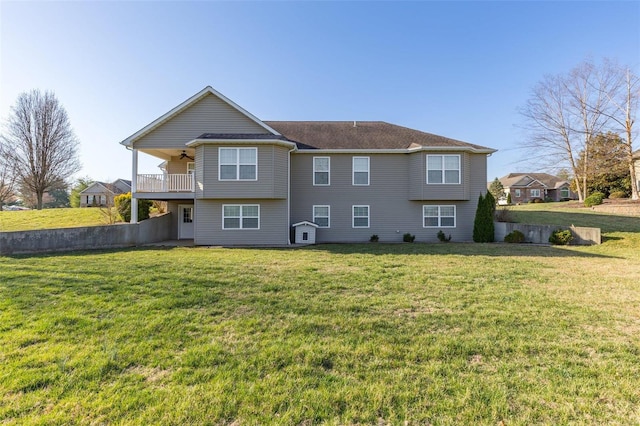 back of property with a yard and a ceiling fan