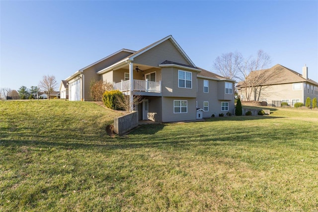 rear view of house with a yard, a ceiling fan, and a garage