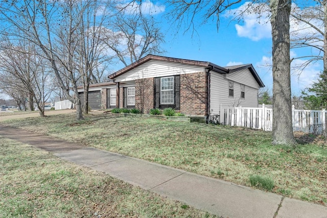 view of front facade featuring brick siding, a front lawn, and fence