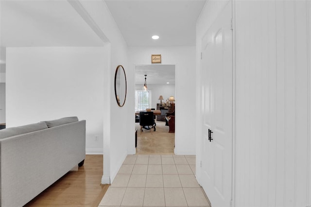 corridor with light tile patterned flooring, recessed lighting, and baseboards