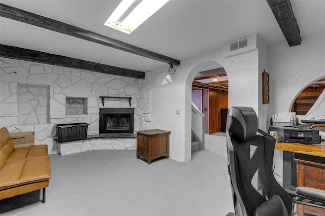 home office featuring visible vents, beamed ceiling, finished concrete floors, a textured wall, and arched walkways