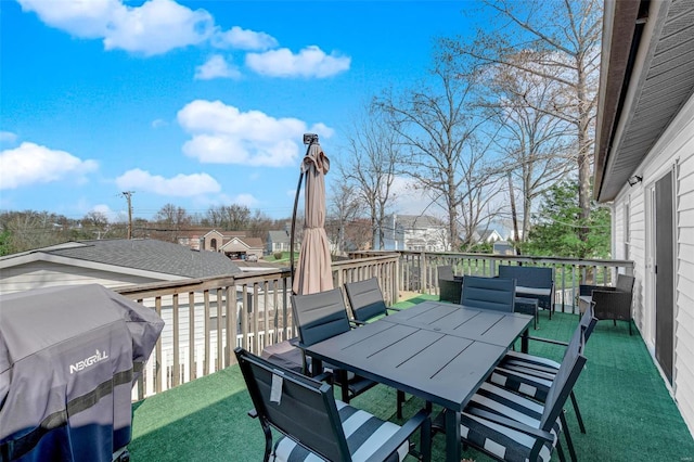 wooden terrace with outdoor dining area and a grill