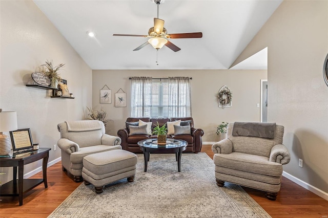 living area featuring baseboards, lofted ceiling, wood finished floors, and a ceiling fan