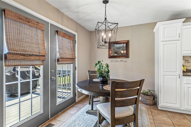 dining space with light tile patterned floors, visible vents, and a chandelier