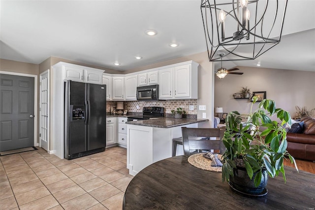kitchen with black appliances, tasteful backsplash, a peninsula, light tile patterned flooring, and white cabinets